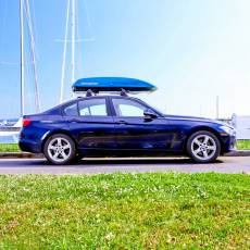 Blue rooftop cargo carrier on sports car roof